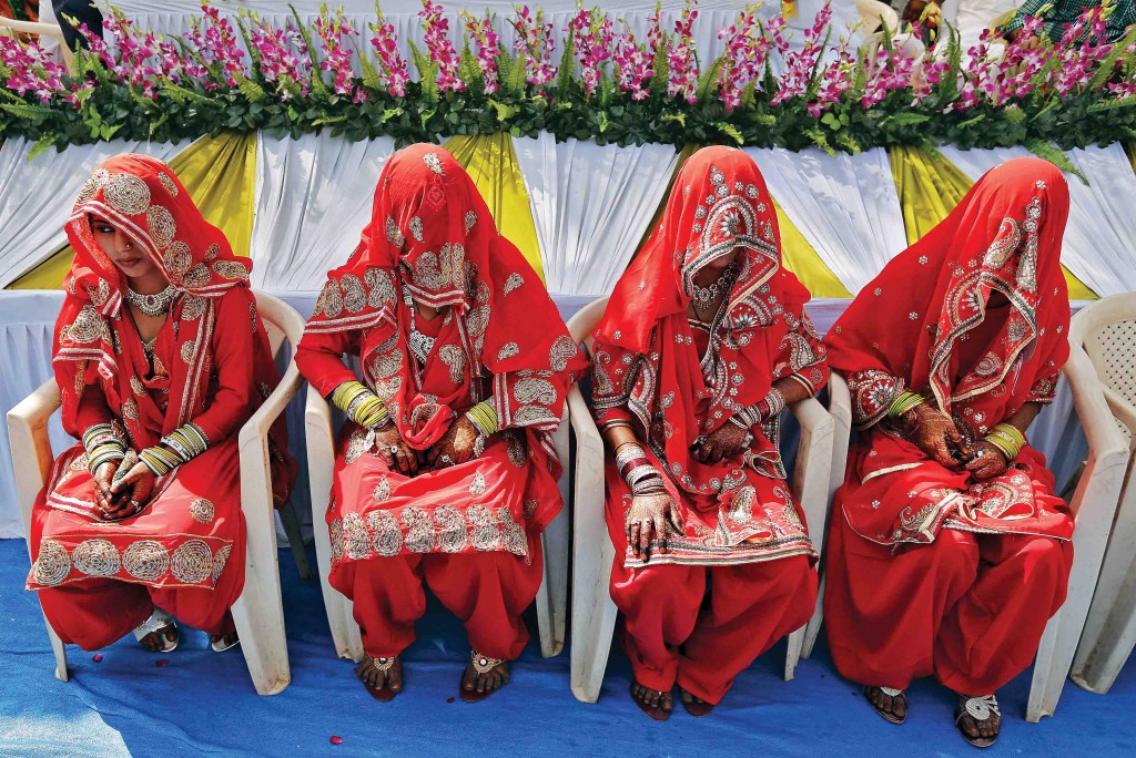Muslim brides sit as they wait for the start of a mass marriage ceremony in Ahmedabad