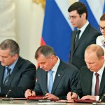 क्रीमिया के रूस में विलय की संधि पर हस्ताक्षर करते पूतिन