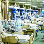 Medical workers in protective suits attend to novel coronavirus patients at the intensive care unit (ICU) of a designated hospital in Wuhan